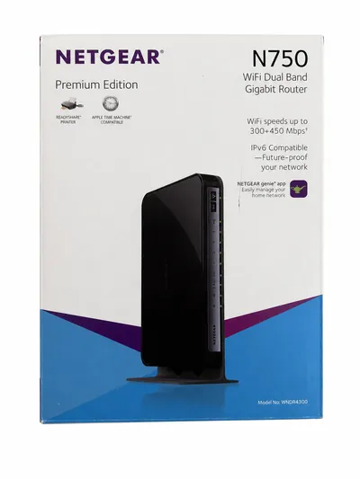 The NETGEAR N750 retail box, front: the router pictured upright beside the N750 Premium Edition name on a white and blue panel.