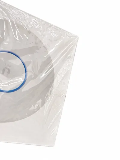 One of the two access points, stored in a clear sealed bag, its white face and blue indicator ring visible through the plastic.