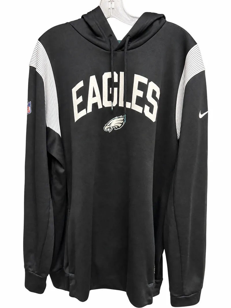 The front of the black Nike Eagles hoodie on a hanger, with white EAGLES lettering, the team logo, white ribbed shoulder panels and an NFL shield at the chest.